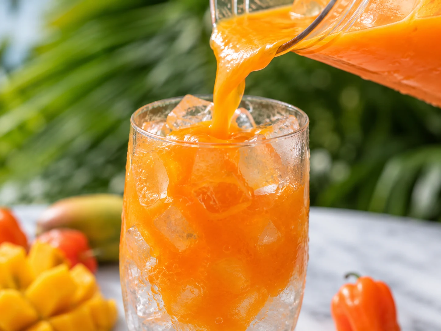 mango habanero mocktail pouring mango over ice process shot