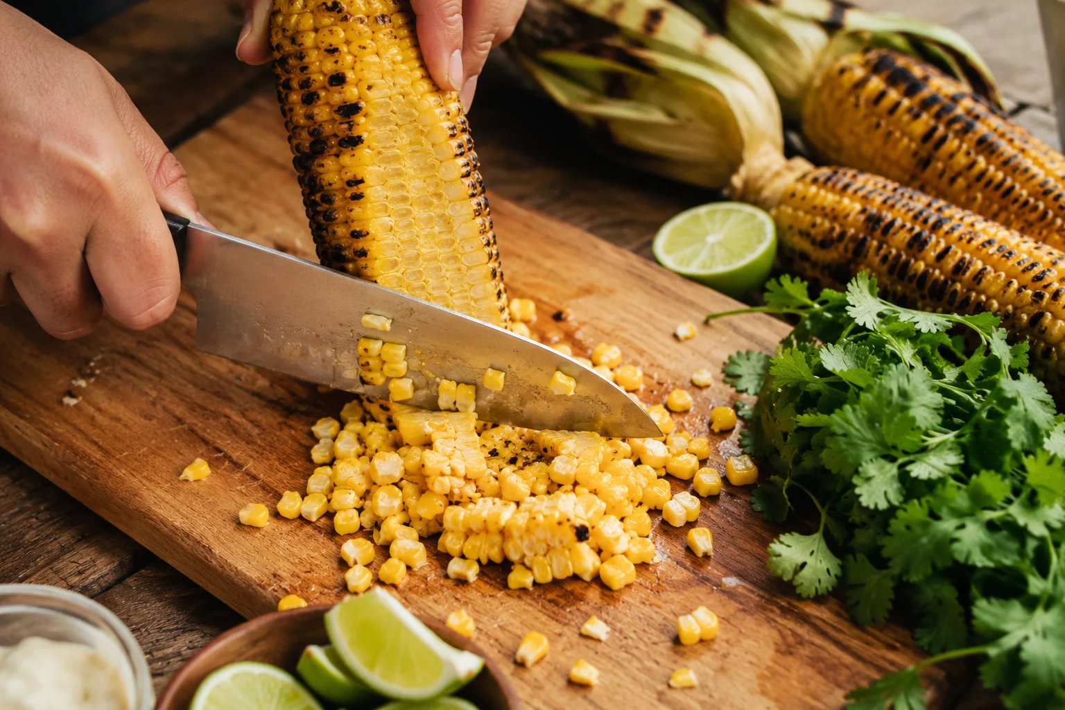 Grilled corn being sliced off the cob