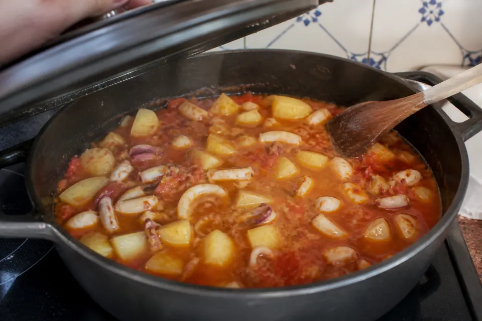 Papas con choco gently simmering in a wide pot